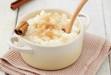 Arroz con leche, clavos de olor y canela acompañado de una cucharada de madera