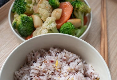 Bowl de arroz acompañado de ensalada de coliflor, brócoli y zanahoria