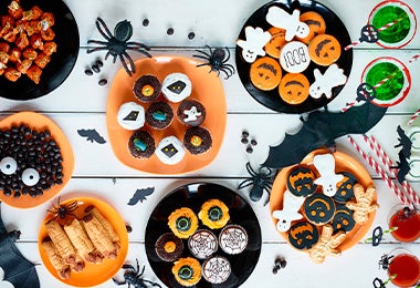 Mesa de dulces y postres con decoración temática de Halloween