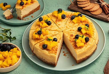 Un pie de mango con base de galletas y decorado con frutas