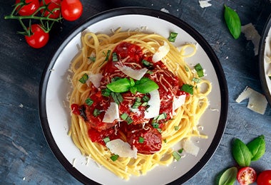 Espagueti con salsa pomodoro, queso rallado y hierbas aromáticas