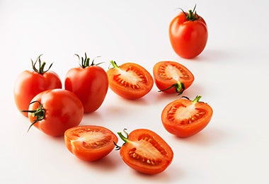 mGrupo de tomates, algunos cortados por la mitad, para usar en una salsa pomodoro