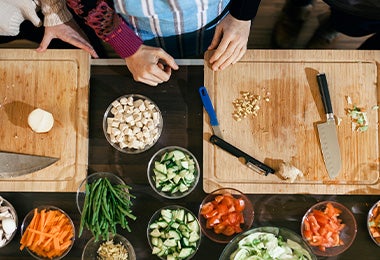 Tabla de corte con cuchillos y verduras cortadas 